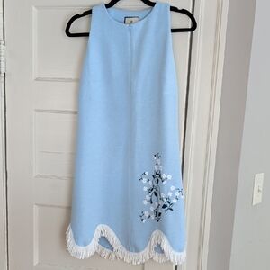 Tuckernuck Light Blue Rivers Dress with a scalloped tassel hem and white floral